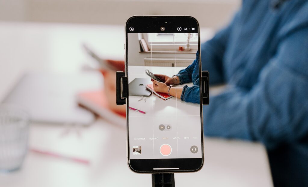 Blick durch ein Smartphone auf einen Schreibtisch